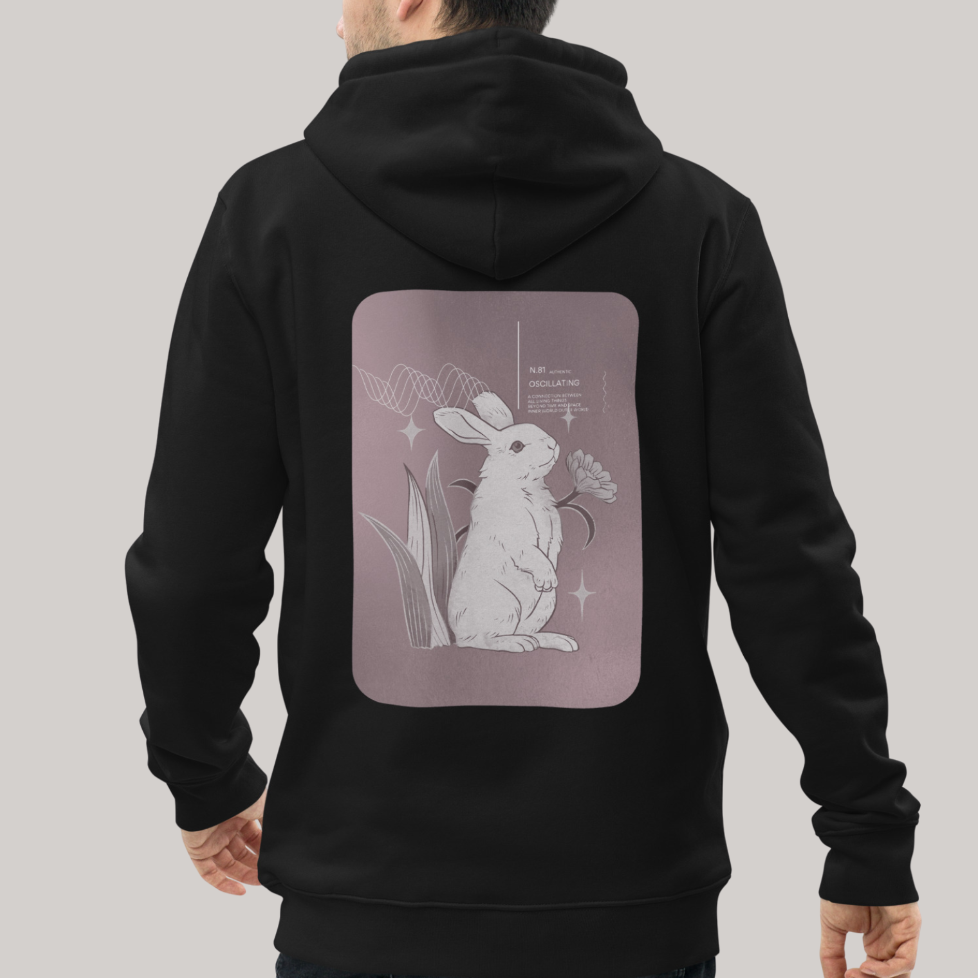 Oscillating bunny rabbit back design: hooded sweatshirt, black hoodie, male model. Luxury organic cotton