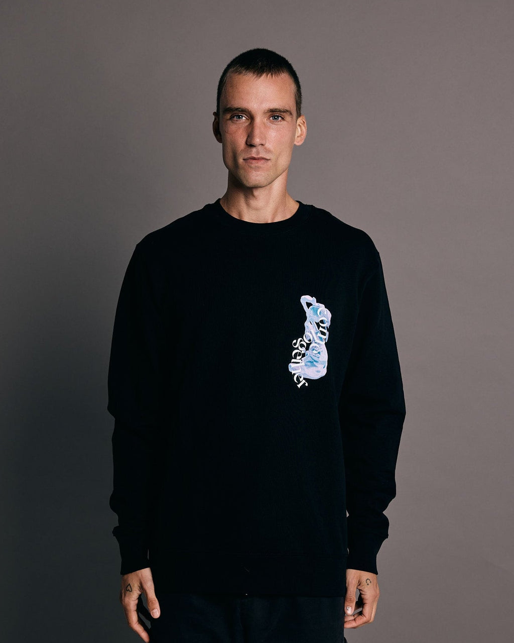 Man wearing a black sweatshirt crewneck with graphic 'come together' in luxury streetwear aesthetic