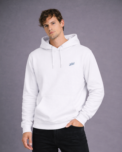 Angled front view of a model wearing a white hoodie with gray chest embroidery and a kangaroo pocket.
