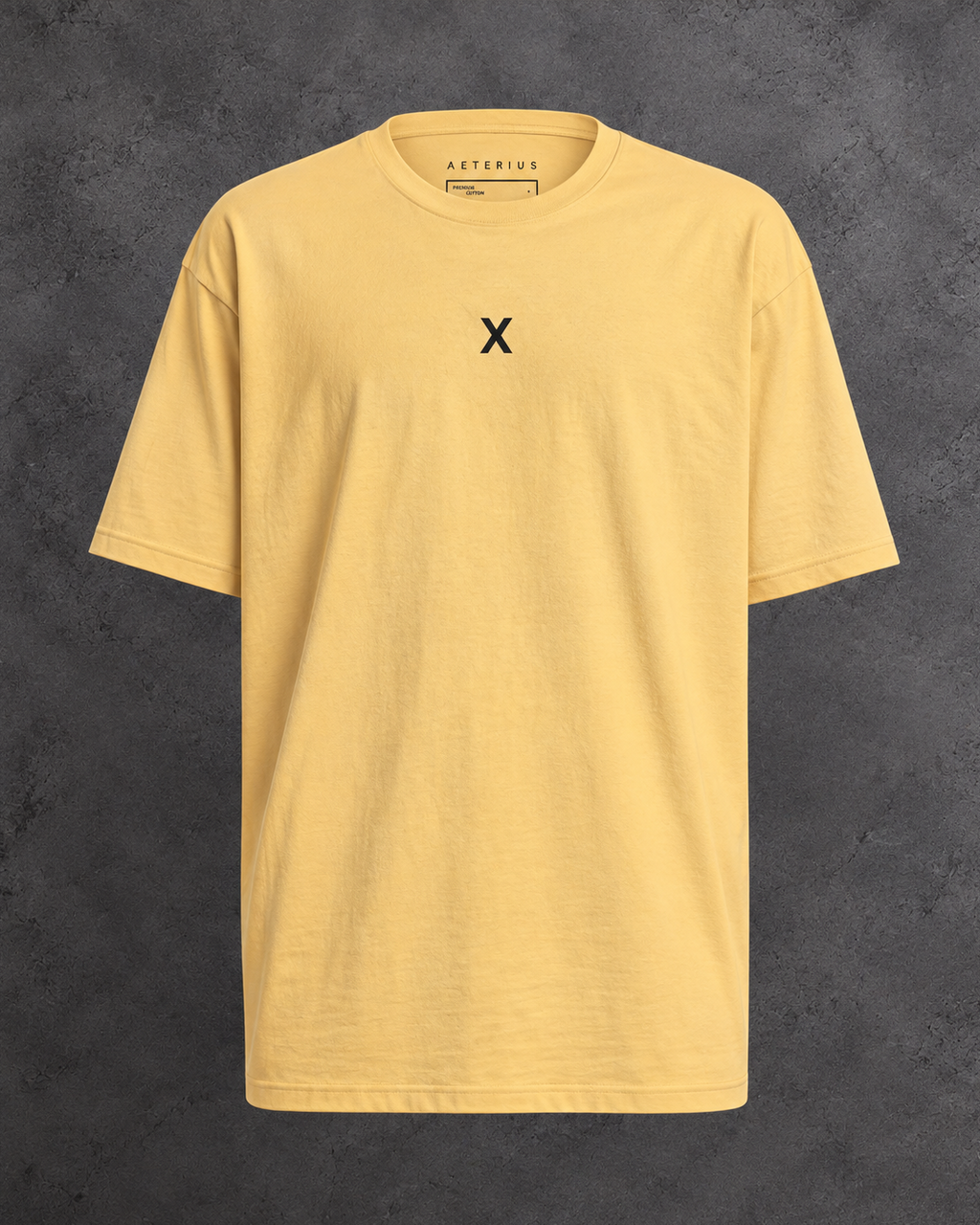Golden yellow crew-neck t-shirt with a small black X on the chest, displayed against a gray background.