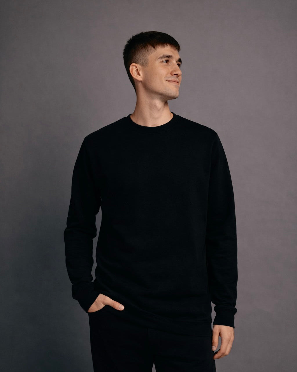 Model wearing black crewneck in relaxed fit streetwear