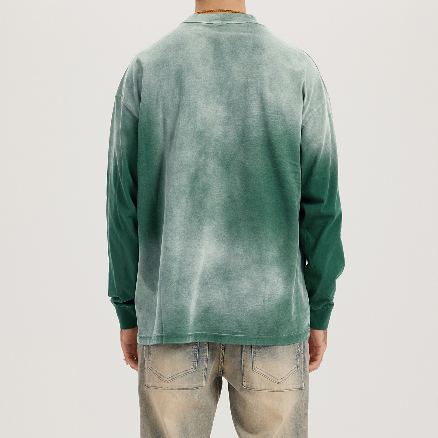 back of model wearing faded green crewneck, washed dyed color, luxury streetwear aesthetic