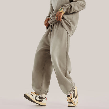 beige baggy pants in streetwear sweatpants style, posing with legs to the front showing baggy pants, luxury streetwear aesthetic