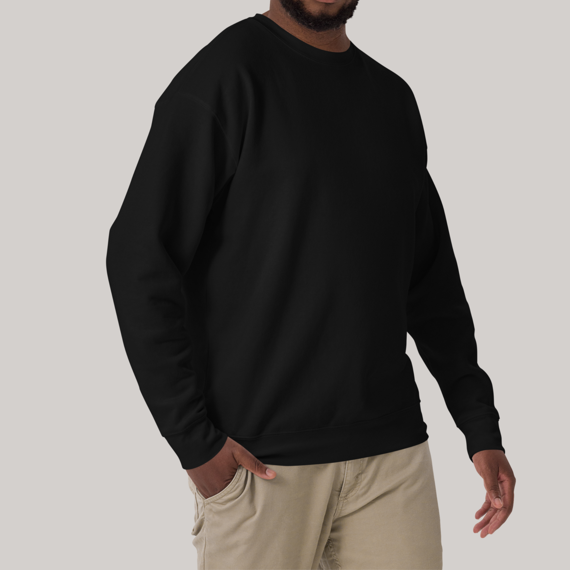 model from neck down in black crewneck sweatshirt with one hand in front beige pants pocket