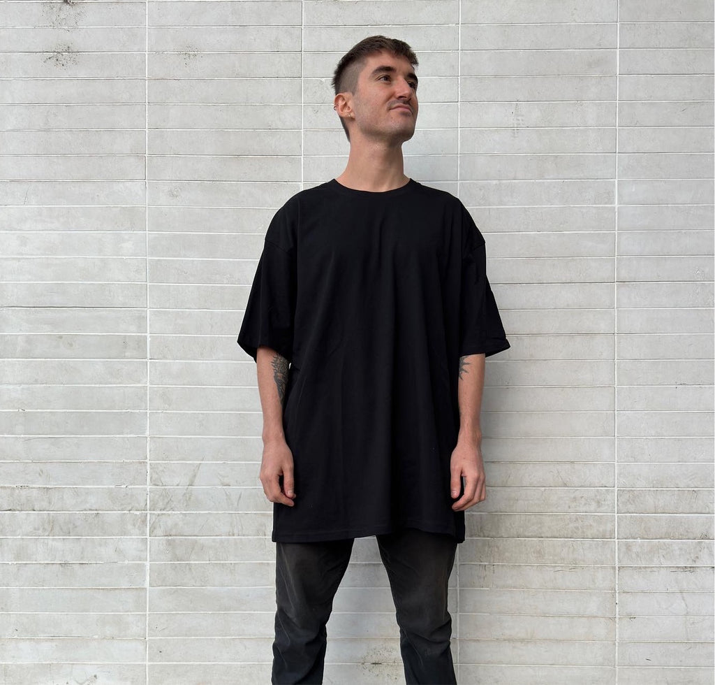 modeling oversized black t-shirt; drop shoulder black t-shirt; streetwear model shoot; white wall with squares