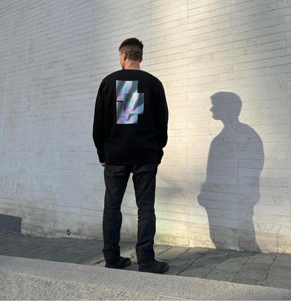 Back of model standing in urban street wearing luxury streetwear black crewneck with graphic sweatshirt back print