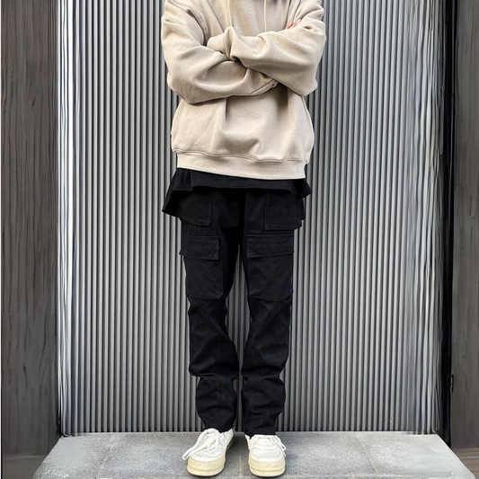 mens black cargo pants, streetwear fit with beige sweatshirt, model standing with arms crossed