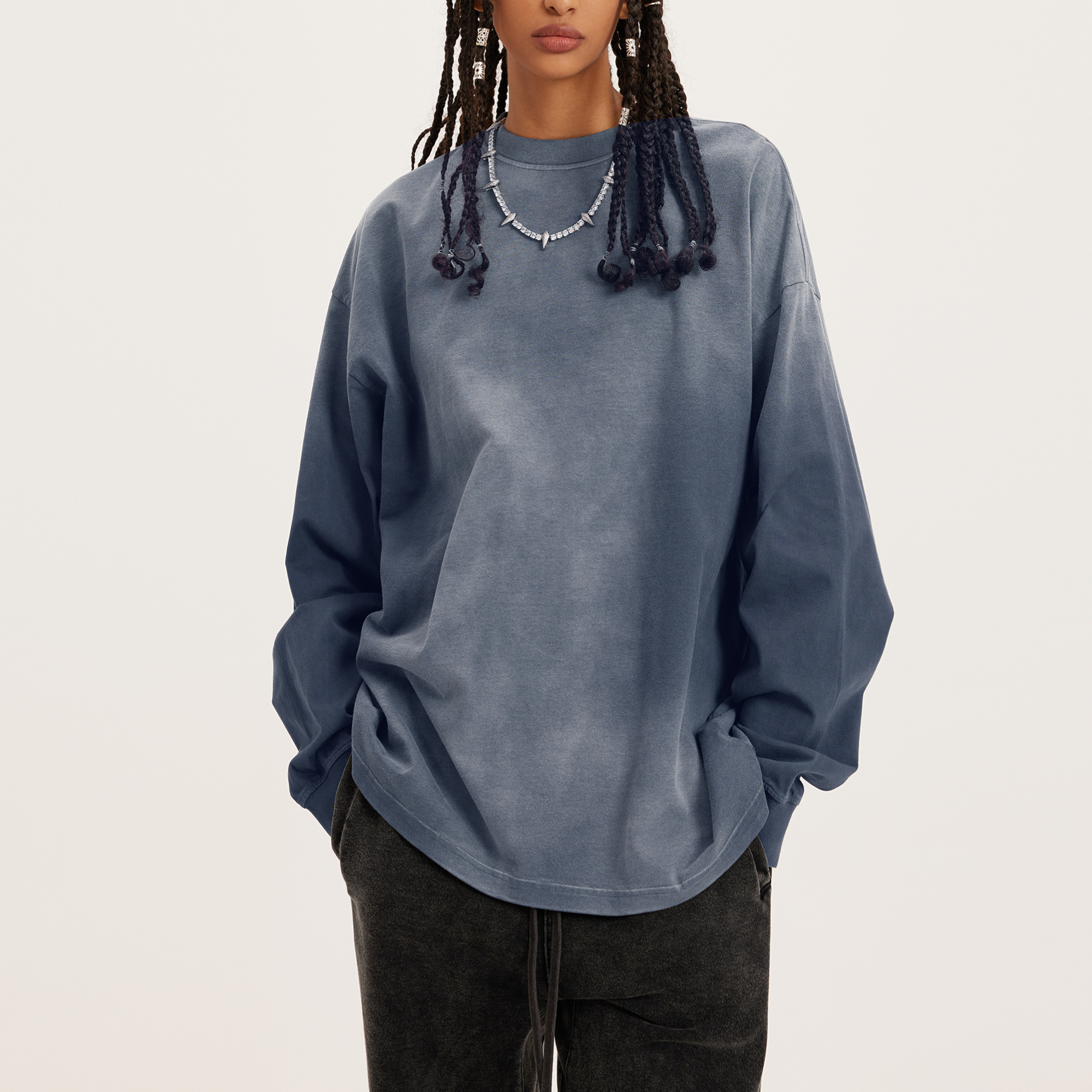 womens oversized crewneck, a long sleeve faded grey crew in streetwear style, model with hands in pockets