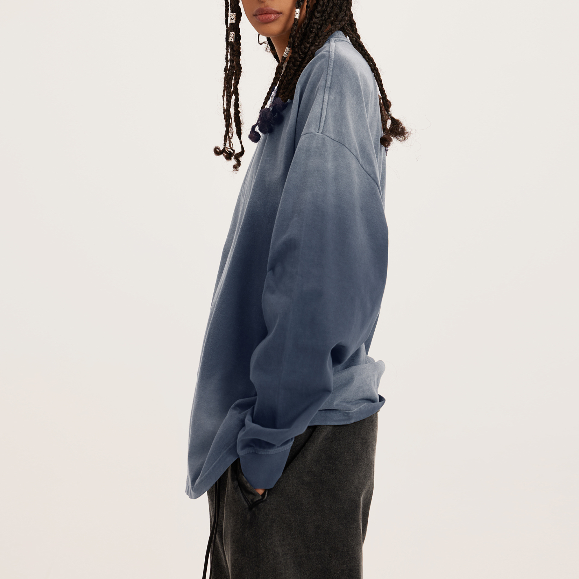 womens oversized dyed grey crewneck from the side, woman model with hands in pants' pocket 