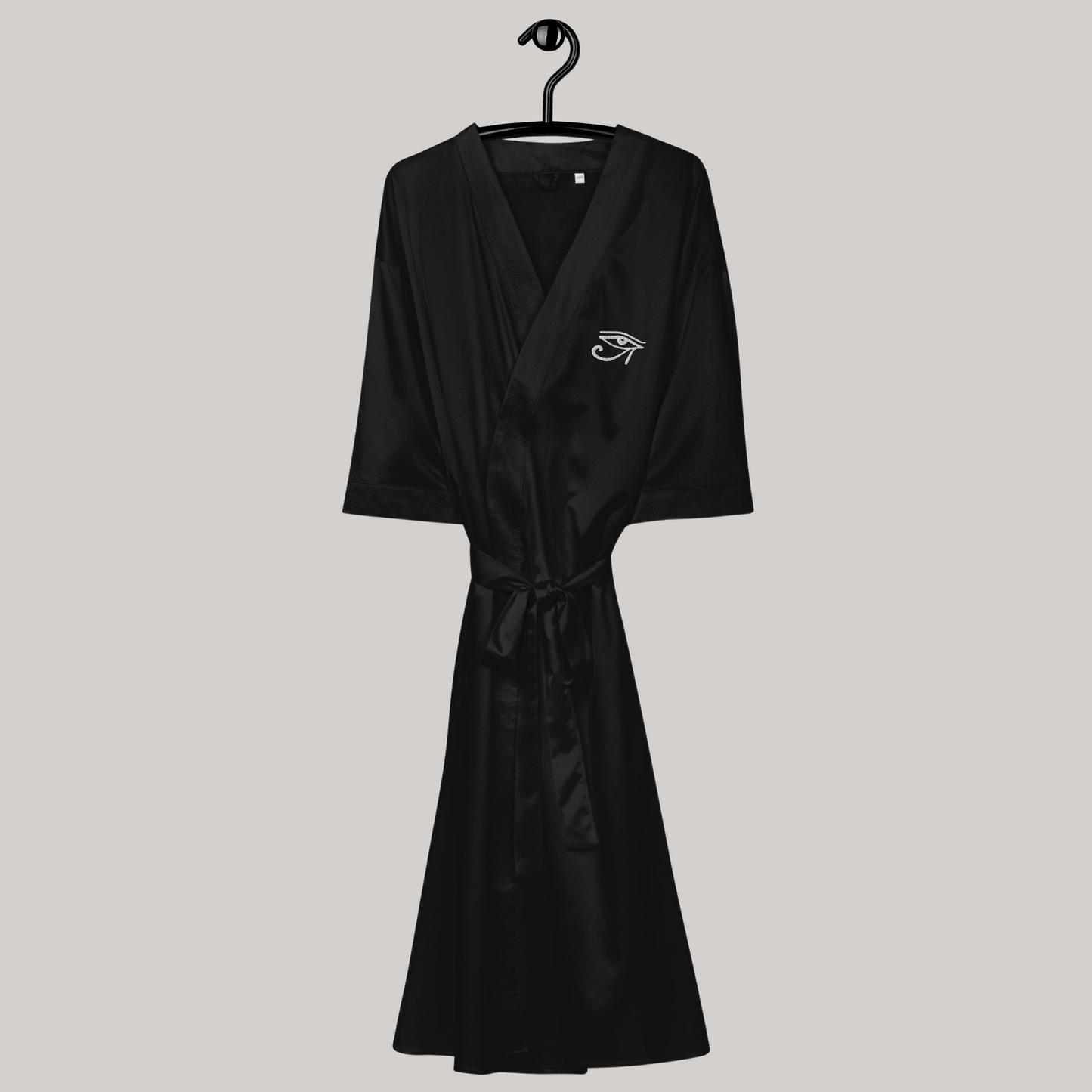 on hanger front satin robe black kimono with eye of horus embroidery on left chest. silky fabric tie belt 3/4 sleeves below knee length