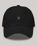 Black dad hat viewed from the front, showing gold X embroidery, ventilation eyelets and a curved brim