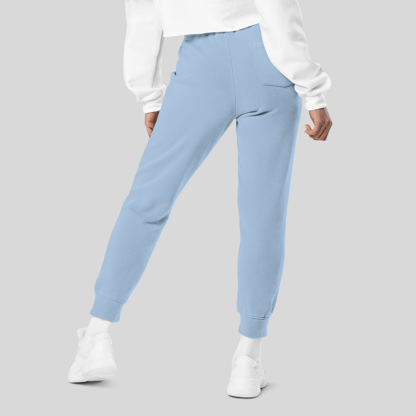 Female model with legs apart wearing light blue joggers; one back pocket