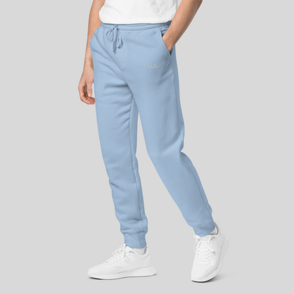 mens light blue joggers in streetwear sweatpants style, hand inside side left pocket, blue drawstrings