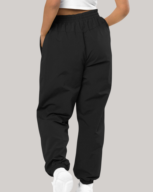 recycled tracksuit trousers cargo pants style 980 back side, female model hands in pockets oversized 